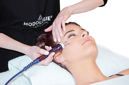 Praticienne Modologie réalisant un soin de stimulation cutanée avec appareil professionnel pour améliorer l’éclat et la fermeté de la peau.